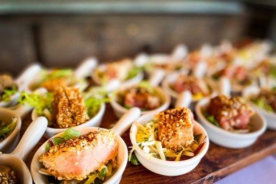 Fauteuils en rotin avec coussins blancs disposés dans un cadre naturel entouré d'arbres et de végétation.