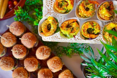 Fauteuils en rotin avec coussins blancs disposés dans un cadre naturel entouré d'arbres et de végétation.