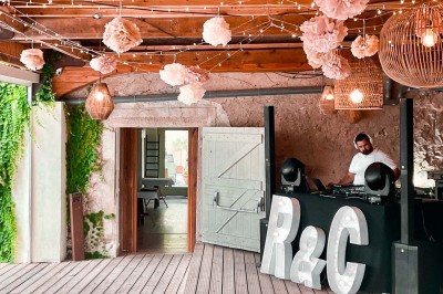 Fauteuils en rotin avec coussins blancs disposés dans un cadre naturel entouré d'arbres et de végétation.