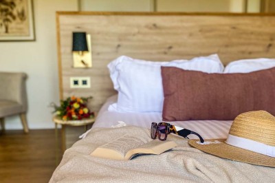 Fauteuils en rotin avec coussins blancs disposés dans un cadre naturel entouré d'arbres et de végétation.