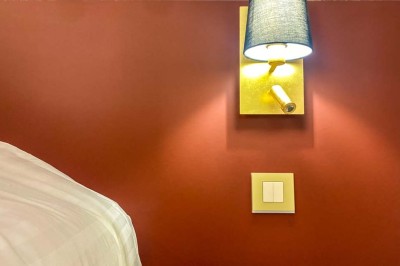 Fauteuils en rotin avec coussins blancs disposés dans un cadre naturel entouré d'arbres et de végétation.