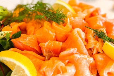 Fauteuils en rotin avec coussins blancs disposés dans un cadre naturel entouré d'arbres et de végétation.