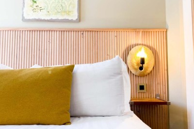 Fauteuils en rotin avec coussins blancs disposés dans un cadre naturel entouré d'arbres et de végétation.