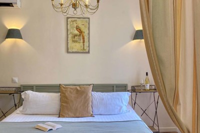 Fauteuils en rotin avec coussins blancs disposés dans un cadre naturel entouré d'arbres et de végétation.