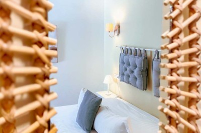 Fauteuils en rotin avec coussins blancs disposés dans un cadre naturel entouré d'arbres et de végétation.