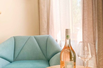 Fauteuils en rotin avec coussins blancs disposés dans un cadre naturel entouré d'arbres et de végétation.