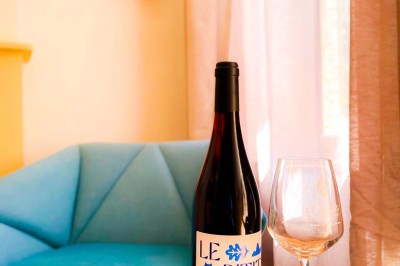 Fauteuils en rotin avec coussins blancs disposés dans un cadre naturel entouré d'arbres et de végétation.