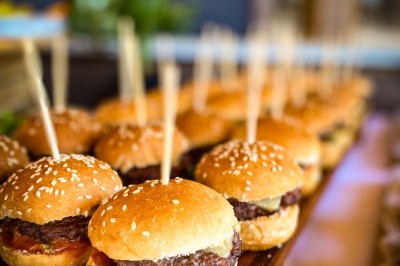 Fauteuils en rotin avec coussins blancs disposés dans un cadre naturel entouré d'arbres et de végétation.