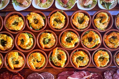 Fauteuils en rotin avec coussins blancs disposés dans un cadre naturel entouré d'arbres et de végétation.