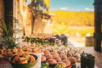 Fauteuils en rotin avec coussins blancs disposés dans un cadre naturel entouré d'arbres et de végétation.