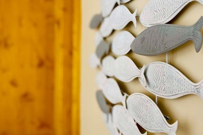 Fauteuils en rotin avec coussins blancs disposés dans un cadre naturel entouré d'arbres et de végétation.