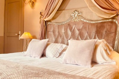 Fauteuils en rotin avec coussins blancs disposés dans un cadre naturel entouré d'arbres et de végétation.