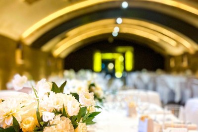 Fauteuils en rotin avec coussins blancs disposés dans un cadre naturel entouré d'arbres et de végétation.