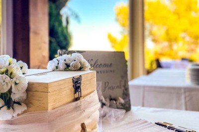 Fauteuils en rotin avec coussins blancs disposés dans un cadre naturel entouré d'arbres et de végétation.