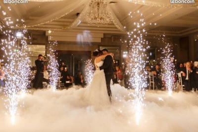 Structure en bois d'une halle éclairée par des lumières violettes, avec un toit en tuiles et des piliers en pierre.