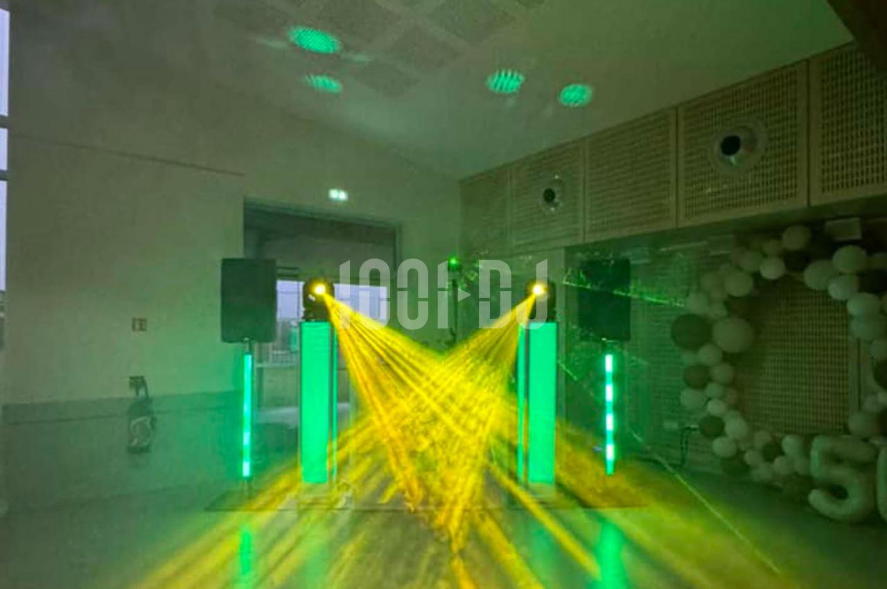 Jeux de lumières vertes et jaunes projetés dans une salle avec des enceintes et une décoration en ballons.