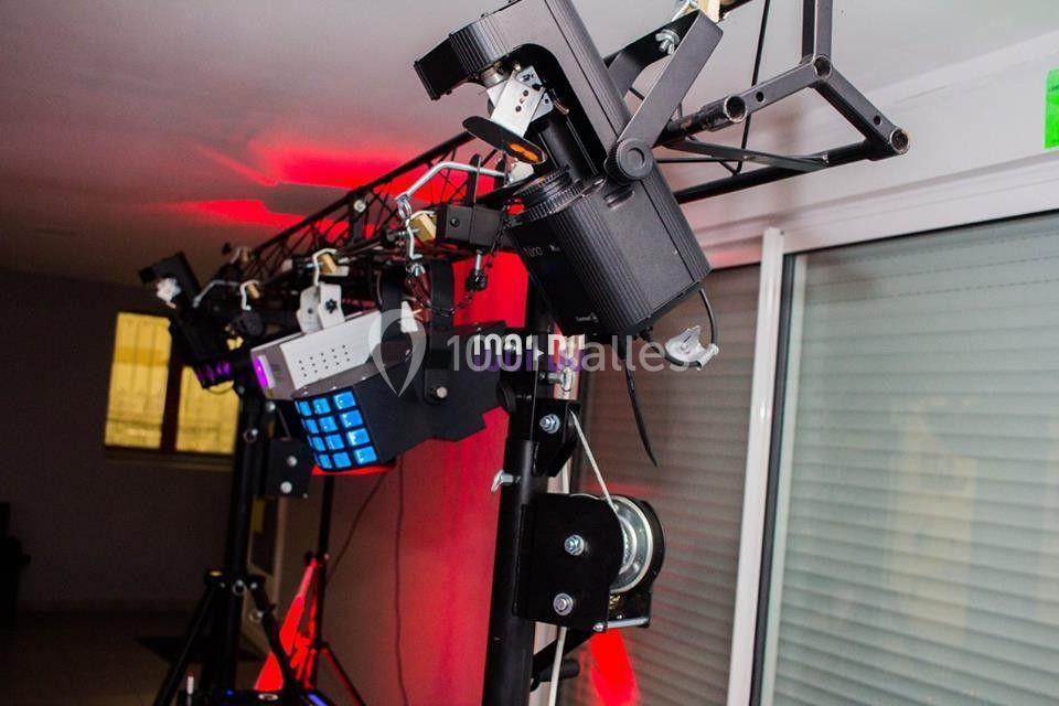 Équipement d'éclairage scénique suspendu avec projecteurs et effets lumineux dans un espace intérieur.