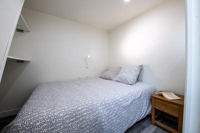 Panneau indiquant les services et parkings du bâtiment Épinette, avec un lampadaire et un paysage en arrière-plan.