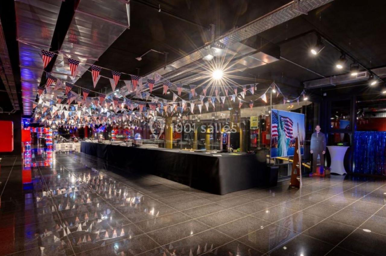 Salle décorée de guirlandes aux couleurs des États-Unis, avec un long comptoir et un sol en carrelage brillant.