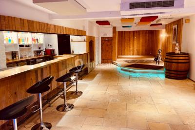 Salle aménagée avec une longue table dressée pour un repas, entourée de chaises pliantes et décorée sobrement.