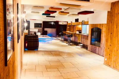 Salle aménagée avec une longue table dressée pour un repas, entourée de chaises pliantes et décorée sobrement.