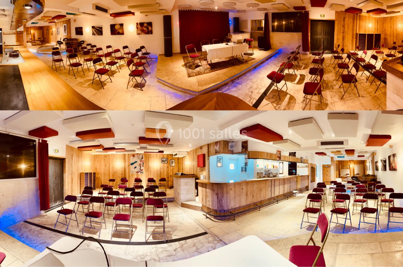 Salle de conférence lumineuse avec chaises disposées en rangées, scène équipée et bar en arrière-plan.