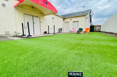 Salle aménagée avec une longue table dressée pour un repas, entourée de chaises pliantes et décorée sobrement.