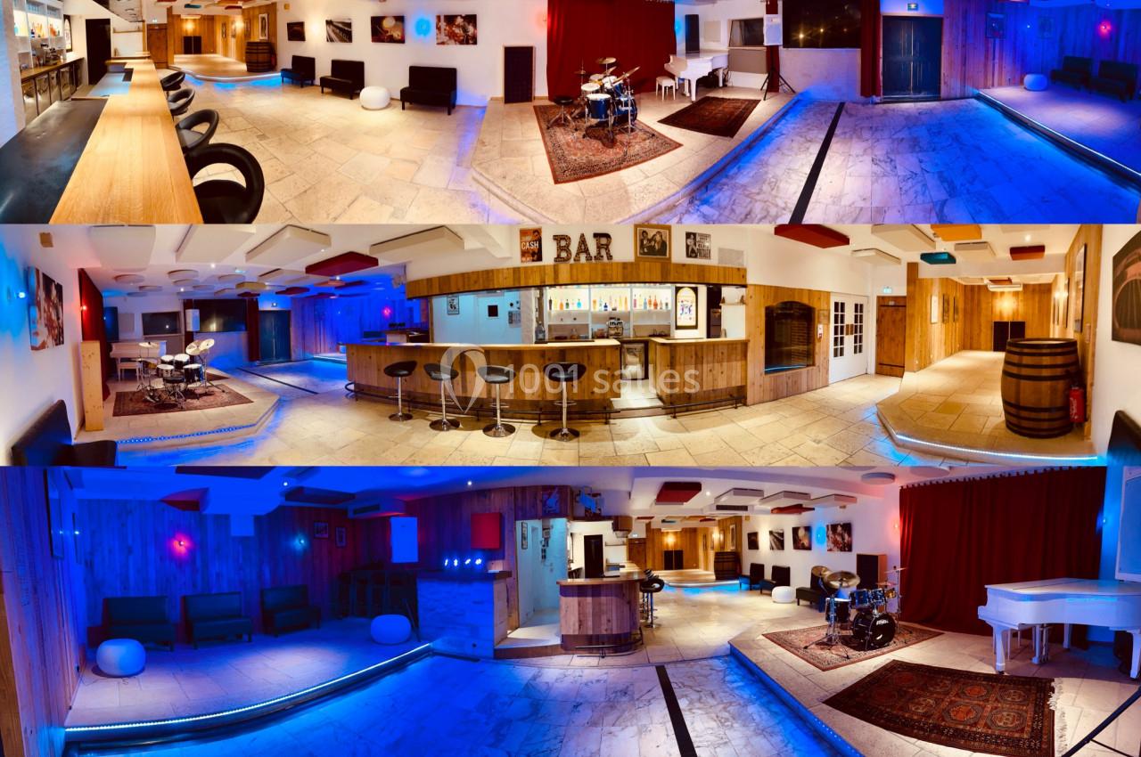 Salle spacieuse avec bar, tabourets, scène musicale, éclairage coloré et décorations modernes en bois et tapis.