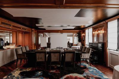 Table dressée pour un petit-déjeuner en extérieur avec vue sur la mer, sous un ciel bleu parsemé de nuages.