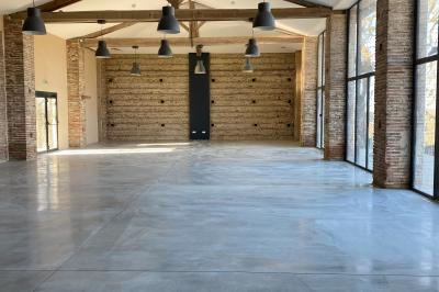 Un couple dans une voiture ancienne quitte un bâtiment entouré de verdure par une journée ensoleillée.