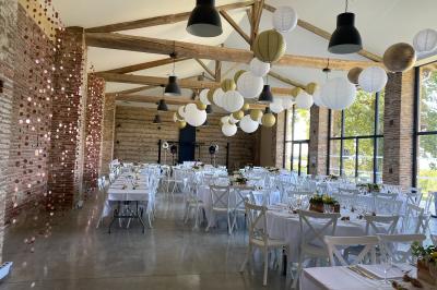 Un couple dans une voiture ancienne quitte un bâtiment entouré de verdure par une journée ensoleillée.