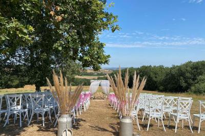 Un couple dans une voiture ancienne quitte un bâtiment entouré de verdure par une journée ensoleillée.