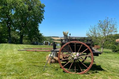 Un couple dans une voiture ancienne quitte un bâtiment entouré de verdure par une journée ensoleillée.