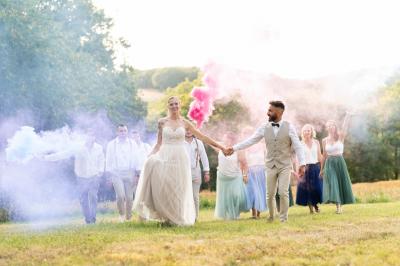 Un couple dans une voiture ancienne quitte un bâtiment entouré de verdure par une journée ensoleillée.