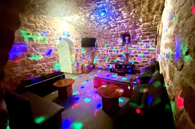 Intérieur d'un bar décoré de fanions, affiches et stickers, avec des tables en bois et des tabourets métalliques.