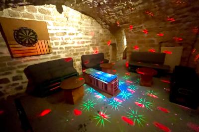 Intérieur d'un bar décoré de fanions, affiches et stickers, avec des tables en bois et des tabourets métalliques.