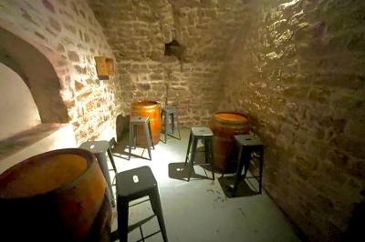 Intérieur d'un bar décoré de fanions, affiches et stickers, avec des tables en bois et des tabourets métalliques.