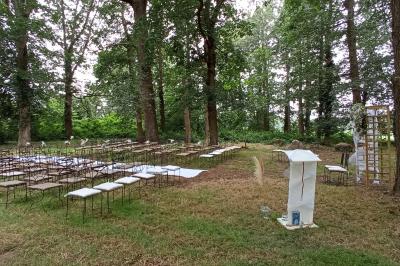 Chambre lumineuse avec lit double, banc capitonné, bureau en bois, lampe et miroir sur un parquet en bois clair.