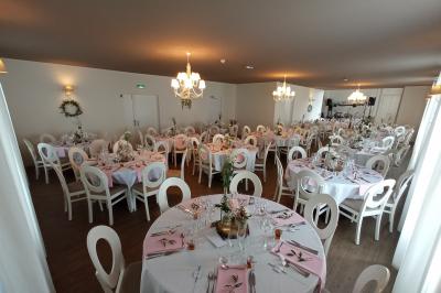 Chambre lumineuse avec lit double, banc capitonné, bureau en bois, lampe et miroir sur un parquet en bois clair.