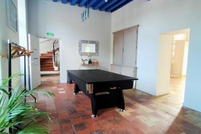 Chambre lumineuse avec lit double, banc capitonné, bureau en bois, lampe et miroir sur un parquet en bois clair.