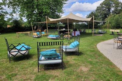 Chambre lumineuse avec lit double, banc capitonné, bureau en bois, lampe et miroir sur un parquet en bois clair.