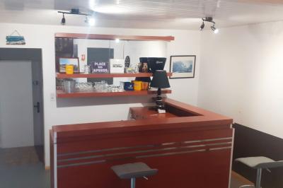 Salle de bain avec douche arrondie, deux lavabos noirs et blancs, miroirs et étagères murales.