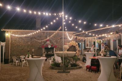 Salle de bain avec douche arrondie, deux lavabos noirs et blancs, miroirs et étagères murales.