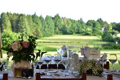 Tente tipi blanche installée sur une pelouse avec une table de pique-nique à proximité, entourée de verdure.