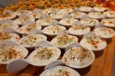 Tente tipi blanche installée sur une pelouse avec une table de pique-nique à proximité, entourée de verdure.