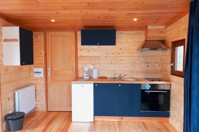 Tente tipi blanche installée sur une pelouse avec une table de pique-nique à proximité, entourée de verdure.