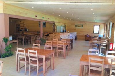 Tente tipi blanche installée sur une pelouse avec une table de pique-nique à proximité, entourée de verdure.