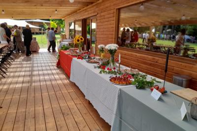 Tente tipi blanche installée sur une pelouse avec une table de pique-nique à proximité, entourée de verdure.