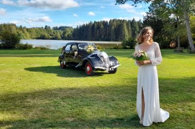 Tente tipi blanche installée sur une pelouse avec une table de pique-nique à proximité, entourée de verdure.