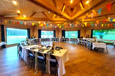 Tente tipi blanche installée sur une pelouse avec une table de pique-nique à proximité, entourée de verdure.